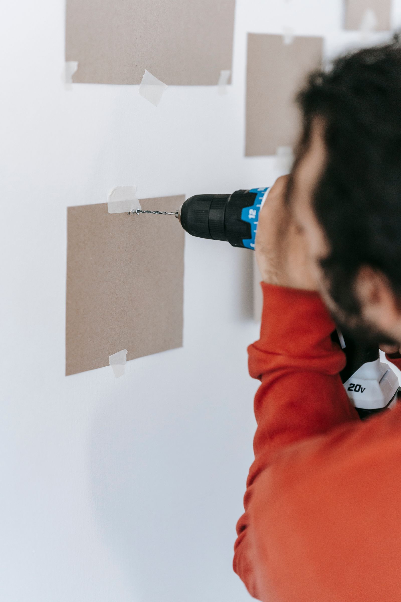 Hausmeister bohrt eine Wand für eine kleine Reparatur in einer Wohnung in Sopron