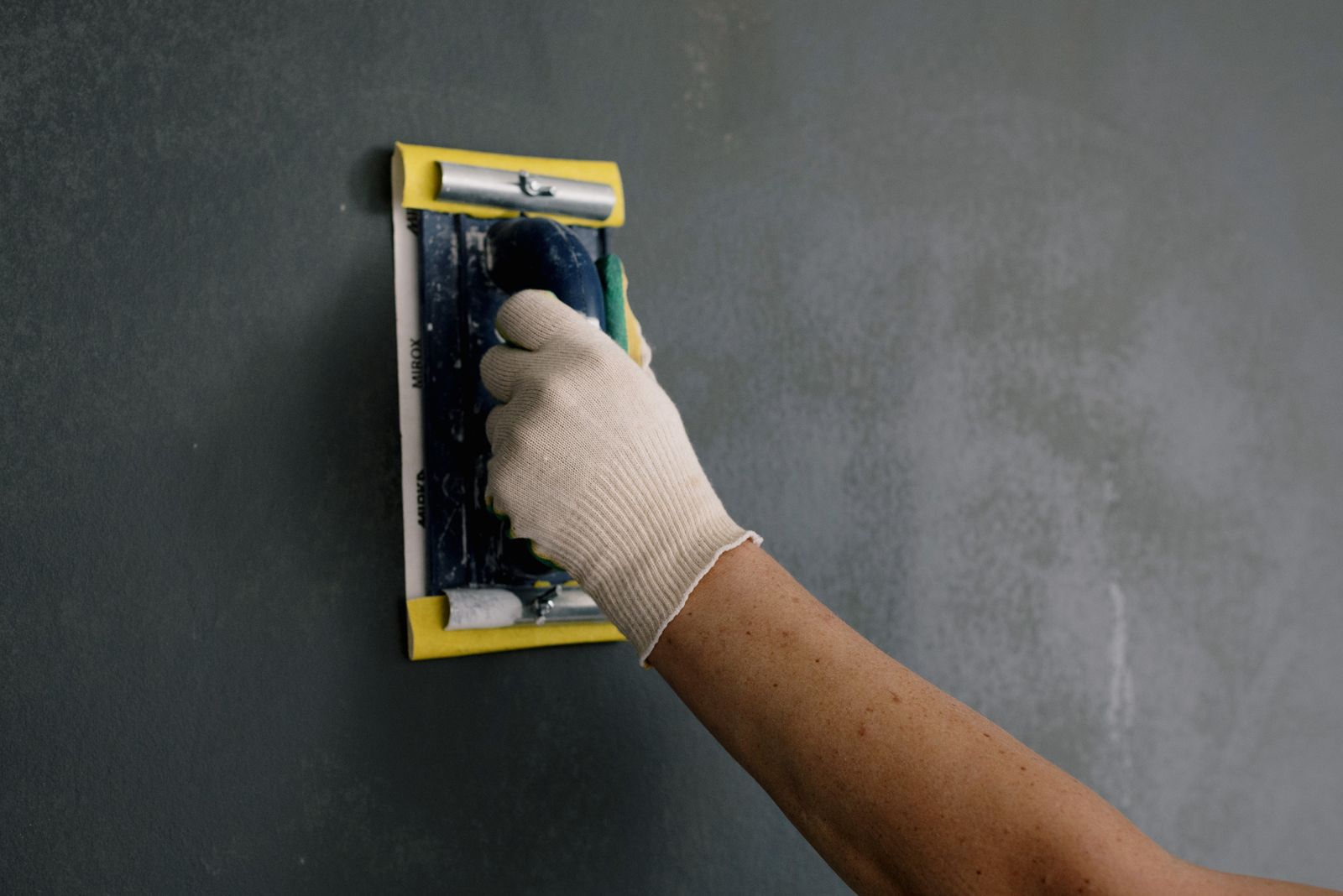 Spachtel glättet eine Wohnungswand vor dem Neuanstrich